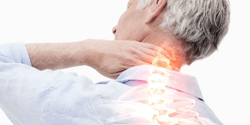 senhor idoso com uma das mãos no pescoço mostrando dor por espondilose cervical.