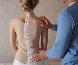 mulher com escoliose sendo examinada por um especialista