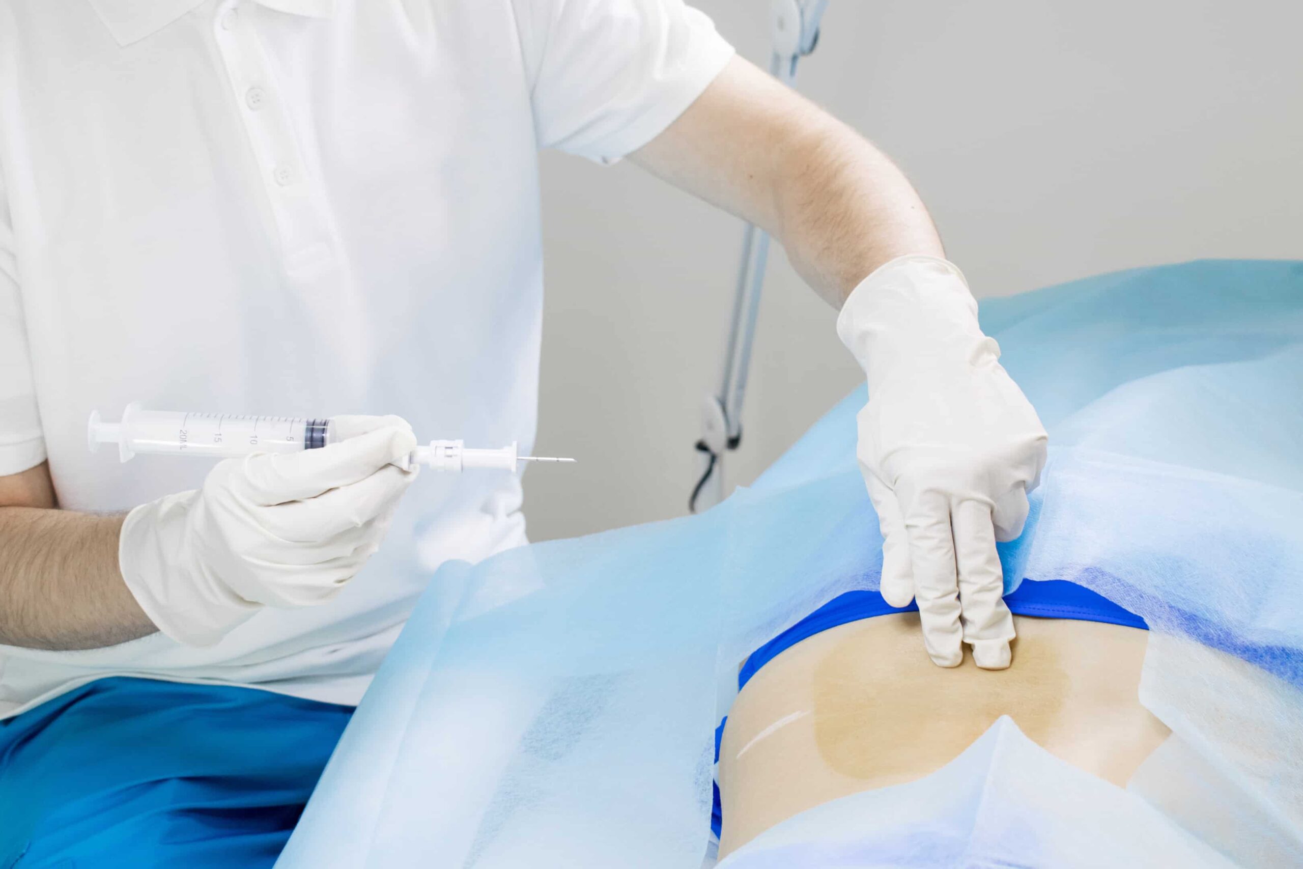 paciente realizando bloqueio facetário com médico