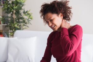 Mulher com sinal de Lhermitte e mão na cervical