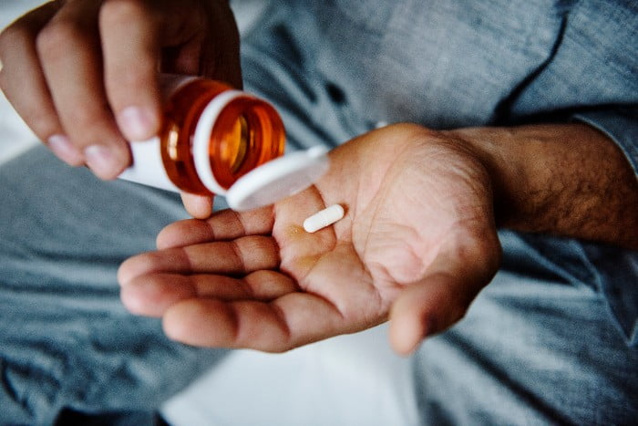 pessoa tomando medicamentos para dor ciática