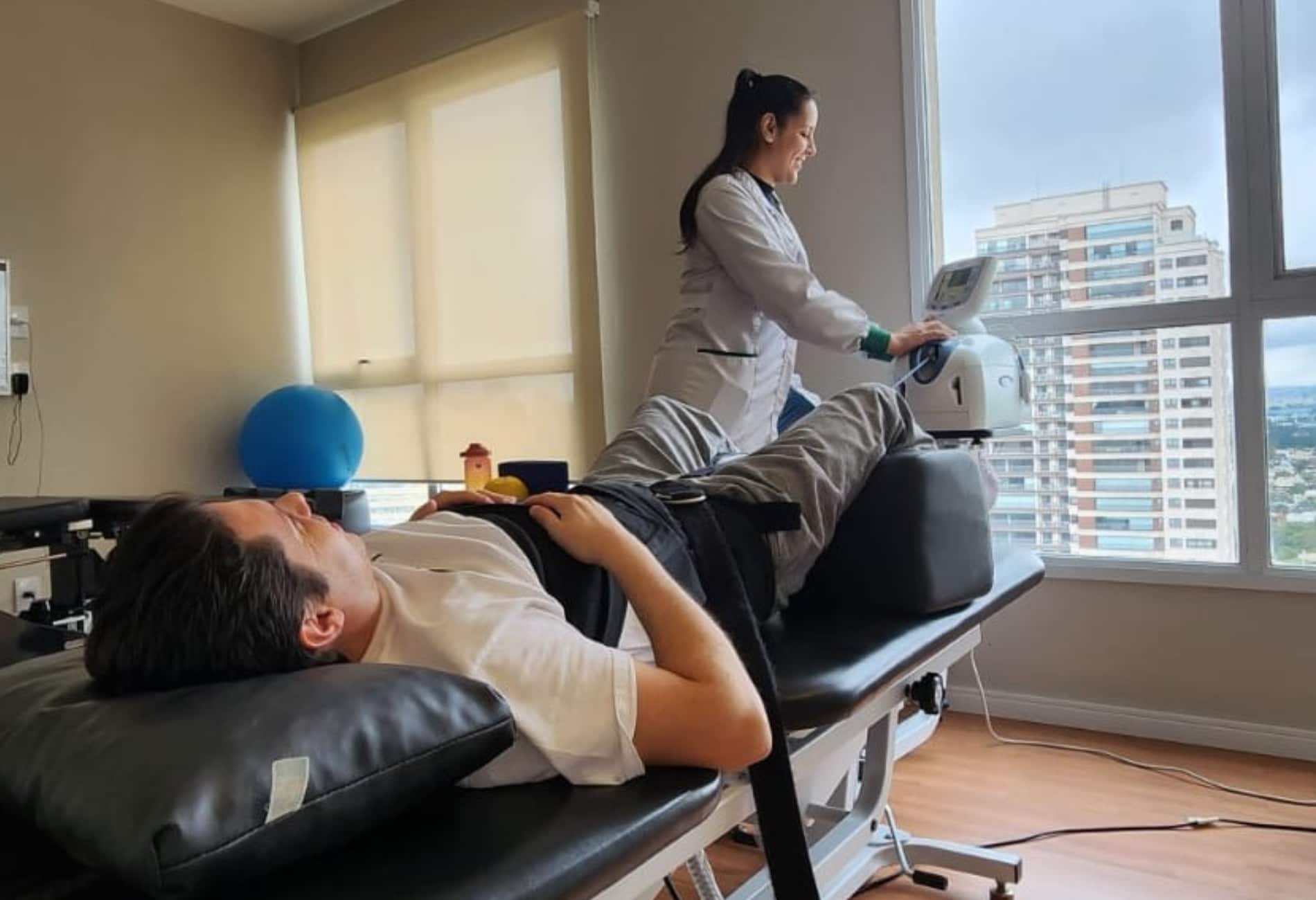 “Paciente realizando tratamento sem cirurgia para saco dural comprimido em mesa de tração”